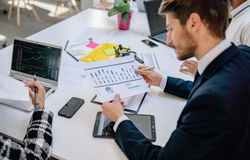 Business team reviewing graphs and data in an office setting.